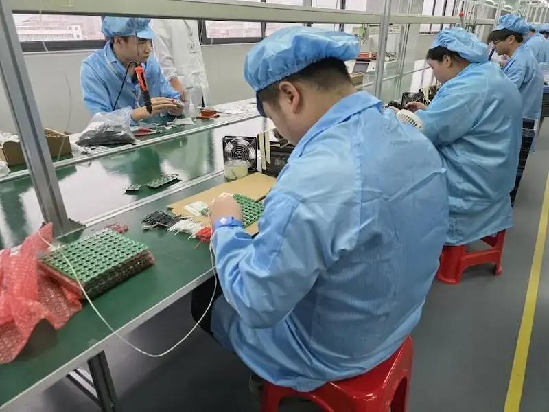 Workers assembling electronics components on a factory production line in Dongguan